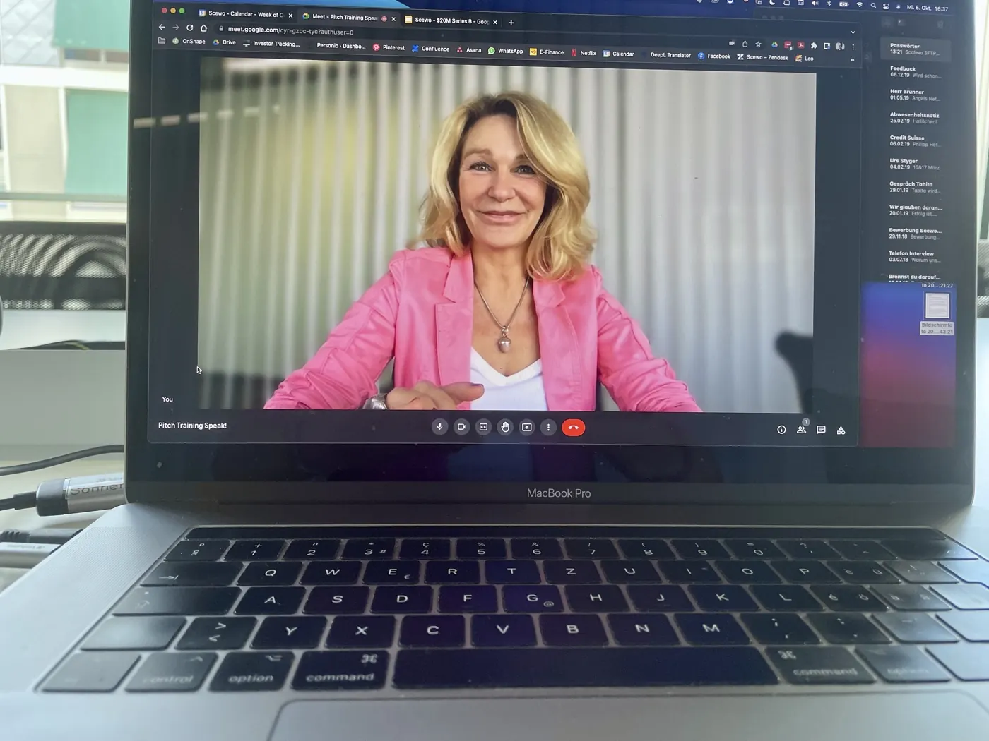 Ein aufgeklappter Laptop zeigt eine Online-Schulung; auf dem Bildschirm spricht die Trainerin.